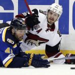 St. Louis Blues' Robert Bortuzzo (41) and Arizona Coyotes' Oliver Ekman-Larsson, of Sweden, slide along the ice while chasing after a loose puck during the first period of an NHL hockey game, Monday, March 27, 2017, in St. Louis. (AP Photo/Jeff Roberson)