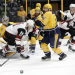 Arizona Coyotes left wing Jamie McGinn (88) and Nashville Predators center Mike Fisher (12) chase after a rebound during the first period of an NHL hockey game Monday, March 20, 2017, in Nashville, Tenn. (AP Photo/Mark Humphrey)