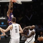Brooklyn Nets' Quincy Acy, right, and Brook Lopez, center, react as Phoenix Suns' Marquese Chriss (0) dunks during the first half of an NBA basketball game Thursday, March 23, 2017, in New York. (AP Photo/Frank Franklin II)