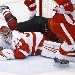 Arizona Coyotes right wing Shane Doan, top, flips over Detroit Red Wings goalie Petr Mrazek (34) after Doan attempted a shot during the first period of an NHL hockey game Thursday, March 16, 2017, in Glendale, Ariz. (AP Photo/Ross D. Franklin)