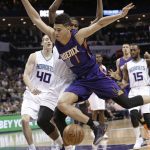 Phoenix Suns' Devin Booker (1) is fouled as he drives past Charlotte Hornets' Michael Kidd-Gilchrist (14) in the first half of an NBA basketball game in Charlotte, N.C., Sunday, March 26, 2017. (AP Photo/Chuck Burton)