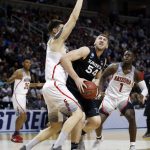 Xavier's Sean O'Mara (54), center, looks to shoot as Arizona center Dusan Ristic, left, defends during the first half of an NCAA Tournament college basketball regional semifinal game Thursday, March 23, 2017, in San Jose, Calif. (AP Photo/Tony Avelar)
