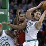 Boston Celtics center Kelly Olynyk (41) grabs a rebound over the arms of Chicago Bulls forward Cristiano Felicio, of Brazil (6) as Celtics guard Marcus Smart, left, loses his balance in the first quarter of an NBA basketball game, Sunday, March 12, 2017, in Boston. (AP Photo/Steven Senne)