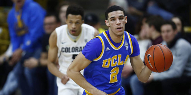 UCLA guard Lonzo Ball, front, picks up a loose ball as Colorado guard Deleon Brown pursues during t...
