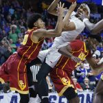 Southern Methodist forward Ben Moore, center, is fouled between Southern California guard Elijah Stewart, left, and guard Jonah Mathews, right, in the second half of a first-round game in the men's NCAA college basketball tournament in Tulsa, Okla., Friday, March 17, 2017. Southern California won 66-65. (AP Photo/Sue Ogrocki)