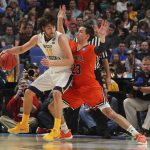 West Virginia forward Nathan Adrian (11) dribbles against Bucknell forward Zach Thomas (23) during the second half of a first-round men's college basketball game in the NCAA Tournament, Thursday, March 16, 2017, in Buffalo, N.Y. West Virginia won, 86-80. (AP Photo/Bill Wippert)