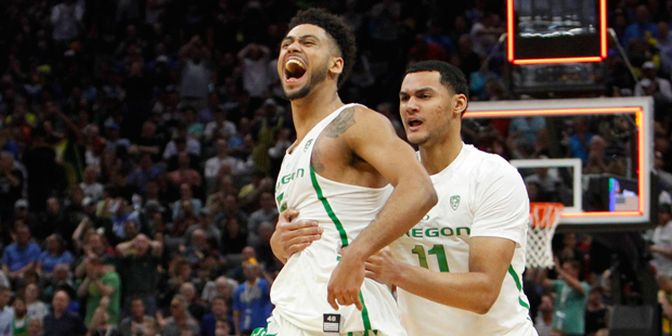 Oregon guard Tyler Dorsey (5) celebrates with teammate Keith Smith (11) after their win over Rhode ...