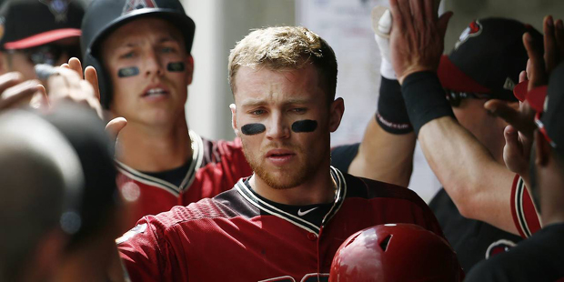 Arizona Diamondbacks' Brandon Drury, middle, gets high-fives from teammates after he scored on a tw...