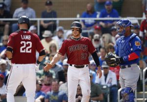 Arizona Diamondbacks' Brandon Drury (27) extends his arm to shake hands with Jake Lamb (22) after Lamb hit a two-run home run as Chicago Cubs' Willson Contreras, right, looks on during the first inning of a spring training baseball game Thursday, March 23, 2017, in Scottsdale, Ariz. (AP Photo/Ross D. Franklin)