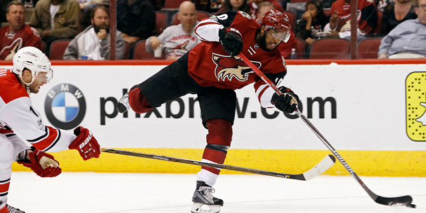 Arizona Coyotes' Anthony Duclair, right, shoots the puck as Carolina Hurricanes' Jordan Staal defen...