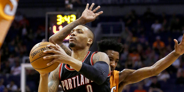 Portland Trail Blazers guard Damian Lillard (0) draws the foul from Phoenix Suns forward Marquese C...