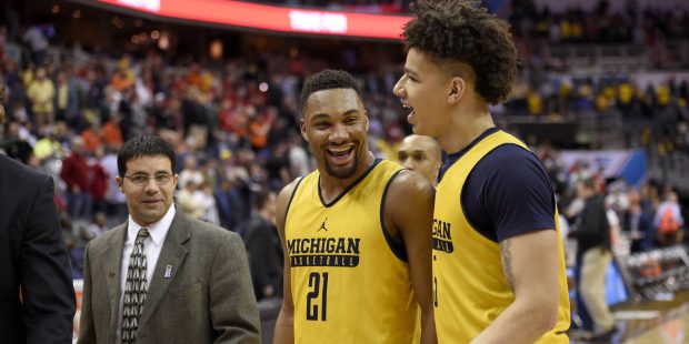 Michigan guard Zak Irvin (21) and forward D.J. Wilson (5) react as they walk off the court after an...