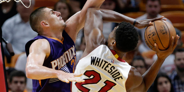 Miami Heat's Hassan Whiteside (21) attempts a basket as Phoenix Suns' Alex Len defends during the f...