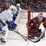Arizona Coyotes' Louis Domingue (35) makes a save on a shot by Vancouver Canucks' Brock Boeser, left, during the first period of an NHL hockey game Thursday, April 6, 2017, in Glendale, Ariz.  The Coyotes defeated the Canucks 4-3. (AP Photo/Ross D. Franklin)