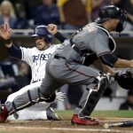 San Diego Padres' Austin Hedges, left, scores as the throw to Arizona Diamondbacks catcher Chris Iannetta is late, on a two-run double by Erick Aybar during the fifth inning of a baseball game in San Diego, Thursday, April 20, 2017. (AP Photo/Alex Gallardo)