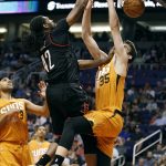Houston Rockets' Nene (42) dunks over Phoenix Suns' Dragan Bender (35) and Jared Dodley (3) during the first half of an NBA basketball game, Sunday, April 2, 2017, in Phoenix. (AP Photo/Ralph Freso)