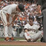 San Francisco Giants manager Bruce Bochy, left, checks Buster Posey on the ground at home plate after he was hit by Arizona Diamondbacks starting pitcher Taijuan Walker in the first inning of a baseball game Monday, April 10, 2017, in San Francisco. Posey was taken out of the game. (AP Photo/Eric Risberg)