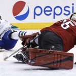 Arizona Coyotes' Louis Domingue, right, makes a save on a shot by Vancouver Canucks' Griffen Molino, left, during the first period of an NHL hockey game Thursday, April 6, 2017, in Glendale, Ariz. (AP Photo/Ross D. Franklin)