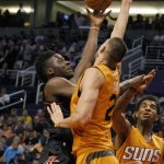 Houston Rockets' Clint Capela, left, shoots over Phoenix Suns' Alex Lin, center, and Marquese Chriss during the first half of an NBA basketball game, Sunday, April 2, 2017, in Phoenix. (AP Photo/Ralph Freso)