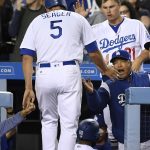 Los Angeles Dodgers' Corey Seager, left, is congratulated by manager Dave Roberts, right, and Joc Pederson after scoring on a double by Justin Turner during the fourth inning of a baseball game, Friday, April 14, 2017, in Los Angeles. (AP Photo/Mark J. Terrill)
