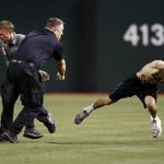 Security guards send a fan, right, to the ground after he ran onto the field following the fifth inning of a baseball game between the Arizona Diamondbacks and the San Diego Padres on Tuesday, April 25, 2017, in Phoenix. (AP Photo/Ross D. Franklin)