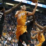 Phoenix Suns guard Devin Booker (1) drives to the basket between Houston Rockets' Lou Williams, left, and Montrezl Harrell during the second half of an NBA basketball game, Sunday, April 2, 2017, in Phoenix. (AP Photo/Ralph Freso)