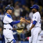 Los Angeles Dodgers catcher Yasmani Grandal, left, congratulates relief pitcher Pedro Baez after the Dodgers defeated the Arizona Diamondbacks 7-1 in a baseball game, Friday, April 14, 2017, in Los Angeles. (AP Photo/Mark J. Terrill)