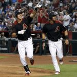 Arizona Diamondbacks' Jake Lamb, left, followed by teammate David Peralta, points to the crowd after his two-run home run against the Los Angeles Dodgers during the first inning of a baseball game, Saturday, April 22, 2017, in Phoenix. (AP Photo/Ralph Freso)