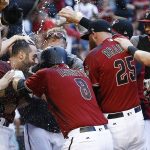 Arizona Diamondbacks' Daniel Descalso, left, celebrates his walkoff two-run home run against the Colorado Rockies with Chris Iannetta (8), Archie Bradley (25) and other teammates at home plate during the 13th inning of a baseball game Sunday, April 30, 2017, in Phoenix. (AP Photo/Ross D. Franklin)
