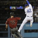 Los Angeles Dodgers' Enrique Hernandez, right, misses a throw from Corey Seager as Arizona Diamondbacks' Jeremy Hazelbaker safely takes second base during the fifth inning of a baseball game, Saturday, April 15, 2017, in Los Angeles. (AP Photo/Jae C. Hong)