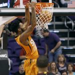 Phoenix Suns' Derrick Jones Jr., top, dunks the ball in front of Houston Rockets' Eric Gordon during the first half of an NBA basketball game, Sunday, April 2, 2017, in Phoenix. (AP Photo/Ralph Freso)
