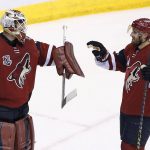 Arizona Coyotes' Louis Domingue (35) celebrates a win against the Vancouver Canucks with Alex Goligoski (33) as time expires in the third period of an NHL hockey game Thursday, April 6, 2017, in Glendale, Ariz.  The Coyotes defeated the Canucks 4-3. (AP Photo/Ross D. Franklin)