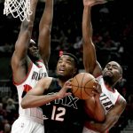Phoenix Suns forward TJ Warren drives to the basket in front of Portland Trail Blazers forwards Noah Vonleh, left, and Maurice Harkless during the first quarter of an NBA basketball game in Portland, Ore., Saturday, April 1, 2017. (AP Photo/Steve Dykes)