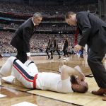 South Carolina head coach Frank Martin, left, checks on Gonzaga center Przemek Karnowski after he was injured during the first half in the semifinals of the Final Four NCAA college basketball tournament, Saturday, April 1, 2017, in Glendale, Ariz. (AP Photo/David J. Phillip)