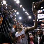Phoenix Suns guard Devin Booker (1) hands an autographed shoe back to a fan as he walks off the court following an NBA basketball game against the Dallas Mavericks, Sunday, April 9, 2017, in Phoenix. The Suns defeated the Mavericks 124-111. (AP Photo/Ralph Freso)