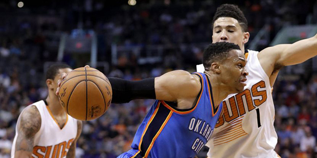 Oklahoma City Thunder guard Russell Westbrook (0) drives past Phoenix Suns guard Devin Booker (1) d...