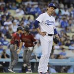 Los Angeles Dodgers starting pitcher Kenta Maeda reacts as Arizona Diamondbacks' Nick Ahmed is greeted by third base coach Tony Perezchica, background left, after hitting a three-run home run during the second inning of a baseball game, Saturday, April 15, 2017, in Los Angeles. (AP Photo/Jae C. Hong)