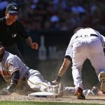 Arizona Diamondbacks' Jake Lamb, right, tags out San Francisco Giants' Eduardo Nunez, left, trying to steal third base as umpire D.J. Reyburn (70) watches during the sixth inning of an opening day baseball game Sunday, April 2, 2017, in Phoenix. (AP Photo/Ross D. Franklin)