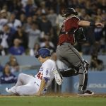Los Angeles Dodgers' Enrique Hernandez, left, scores as Arizona Diamondbacks catcher Jeff Mathis waits for the throw during the fifth inning of a baseball game, Saturday, April 15, 2017, in Los Angeles. (AP Photo/Jae C. Hong)