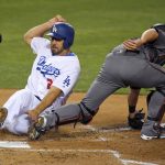 Los Angeles Dodgers Rob Segedin, left, scores on a sacrifice fly hit by Logan Forsythe as Arizona Diamondbacks catcher Jeff Mathis takes a late throw during the second inning of a baseball game, Monday, April 17, 2017, in Los Angeles. (AP Photo/Mark J. Terrill)