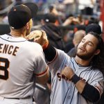 San Francisco Giants' Brandon Crawford, right, jokes around with Hunter Pence (8) in the dugout prior to a baseball game against the Arizona Diamondbacks Tuesday, April 4, 2017, in Phoenix. (AP Photo/Ross D. Franklin)