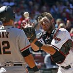 Arizona Diamondbacks' Jeff Mathis, right, reaches up to catch a high-hopper hit by San Francisco Giants' Joe Panik (12) during the fourth inning of an Opening Day baseball game Sunday, April 2, 2017, in Phoenix. (AP Photo/Ross D. Franklin)