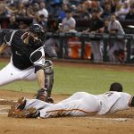 San Francisco Giants' Eduardo Nunez, right, slides around the tag attempt by Arizona Diamondbacks' Chris Iannetta, left, to score during the second inning of a baseball game Wednesday, April 5, 2017, in Phoenix. (AP Photo/Ross D. Franklin)