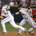 Arizona Diamondbacks' Nick Ahmed (13) gets tagged out in a rundown by San Francisco Giants' Joe Panik (12) as Giants' Eduardo Nunez, back right, watches during the seventh inning of a baseball game Wednesday, April 5, 2017, in Phoenix. The Diamondbacks defeated the Giants 8-6. (AP Photo/Ross D. Franklin)