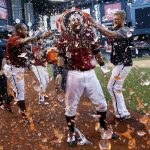 Arizona Diamondbacks' Daniel Descalso, center, celebrates his walkoff two-run home run against the Colorado Rockies with Yasmany Tomas, left, and Jeremy Hazelbaker, right, after a baseball game Sunday, April 30, 2017, in Phoenix. (AP Photo/Ross D. Franklin)