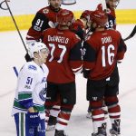 A dejected Troy Stecher (51) skates past Arizona Coyotes' Radim Vrbata as he celebrates his goal with teammates Alexander Burmistrov (91), Anthony DeAngelo (77), Max Domi (16) and Alex Goligoski (33) during the second period of an NHL hockey game Thursday, April 6, 2017, in Glendale, Ariz. (AP Photo/Ross D. Franklin)