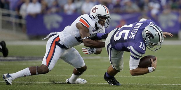 Kansas State quarterback Jake Waters (15) is tackled by Auburn defensive back Johnathan Ford (23) d...