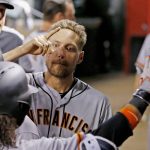 San Francisco Giants' Hunter Pence, middle, celebrates with Brandon Crawford, left, after Crawford hit a home run against the Arizona Diamondbacks during the fifth inning of a baseball game Tuesday, April 4, 2017, in Phoenix. (AP Photo/Ross D. Franklin)