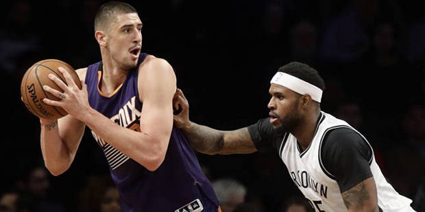 Phoenix Suns' Alex Len, left, is defended by Brooklyn Nets' Trevor Booker (35) during the first hal...
