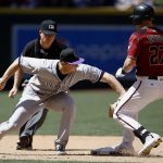 Arizona Diamondbacks' Brandon Drury (27) arrives safely at second base with a double as Colorado Rockies' DJ LeMahieu, left, applies a late tag while umpire Toby Basner, back left, watches during the fourth inning of a baseball game, Sunday, April 30, 2017, in Phoenix. (AP Photo/Ross D. Franklin)